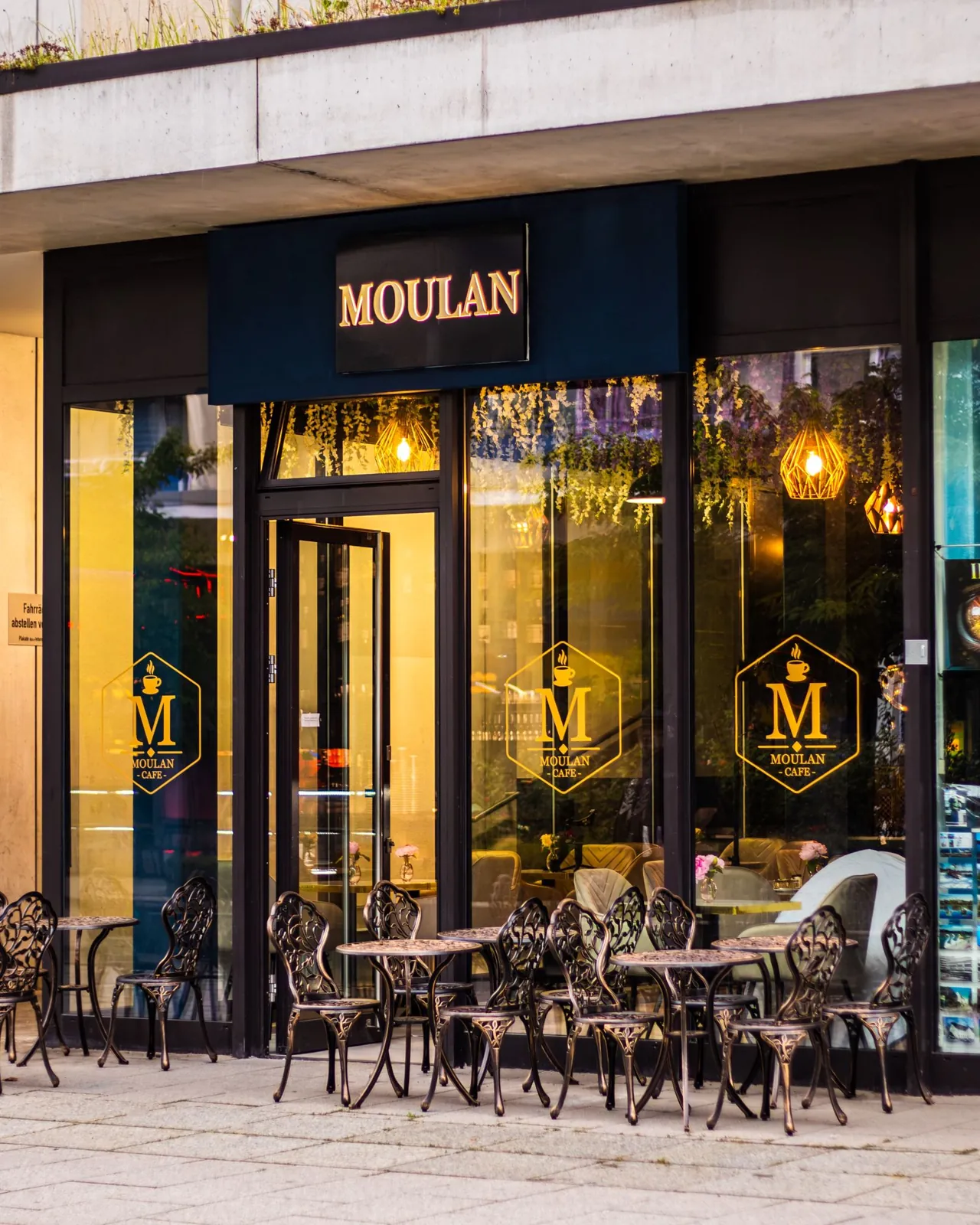 Moulan Café in der Abenddämmerung mit warmer Beleuchtung und Außenplätzen am Rosenhof in Chemnitz